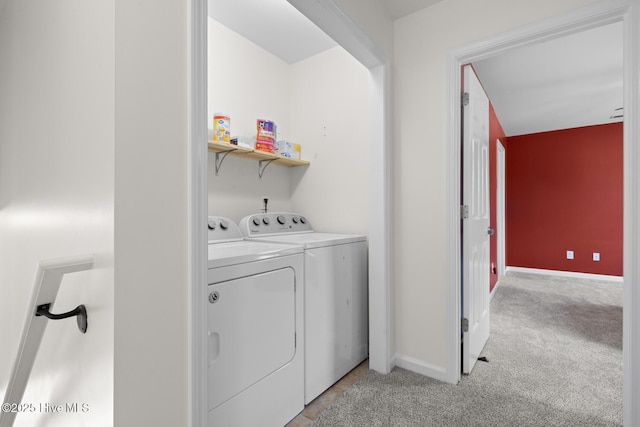 laundry area with washer and clothes dryer, light carpet, and baseboards
