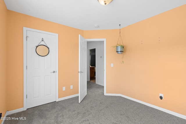 unfurnished bedroom featuring carpet floors and baseboards