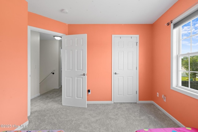 unfurnished bedroom featuring carpet and baseboards