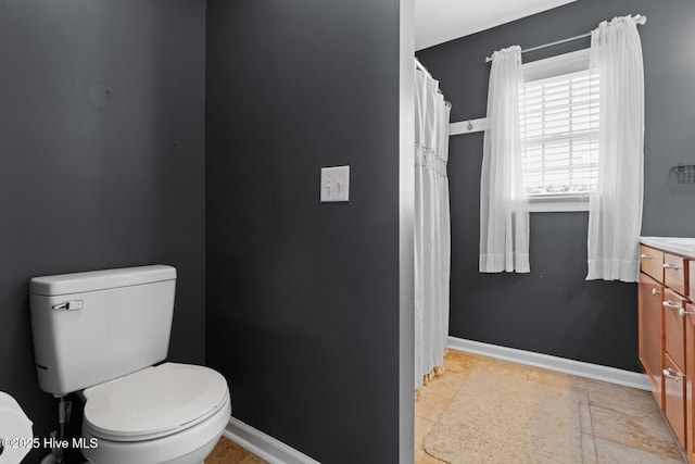 full bathroom featuring toilet, vanity, and baseboards