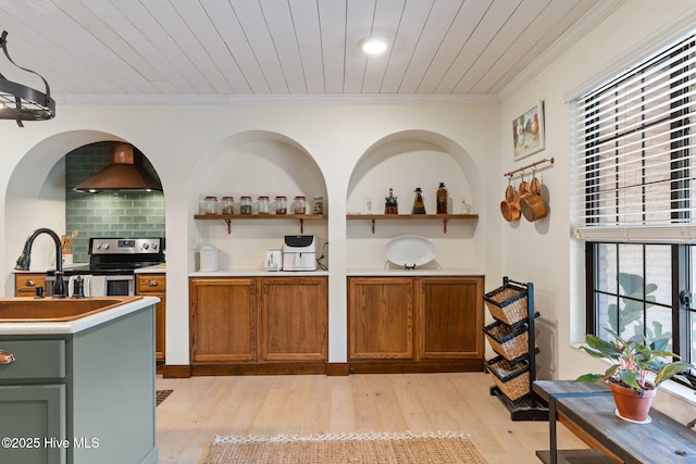 45 Fairway Dr, Shallotte, NC 28470 - bar with stainless steel range with electric stovetop, wall chimney exhaust hood, ornamental molding, light wood finished floors, and decorative backsplash