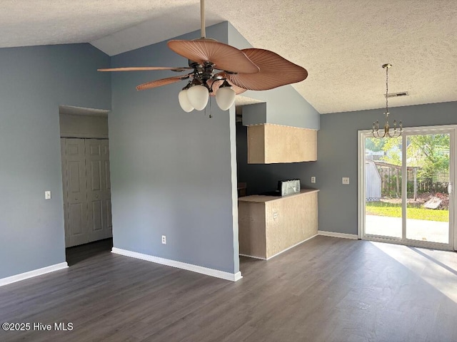 kitchen with vaulted ceiling, dark wood finished floors, a ceiling fan, a textured ceiling, and a chandelier