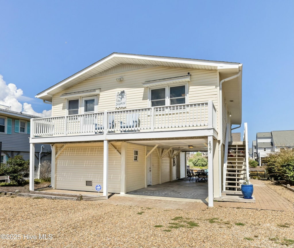 427 Sailfish St, Sunset Beach, NC 28468 - raised beach house featuring stairs, a carport, a garage, and a deck