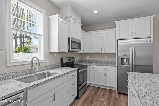 254 Great Egret Way, Beaufort, NC 28516 - kitchen with stainless steel appliances, a sink, white cabinetry, dark wood-type flooring, and light stone counters