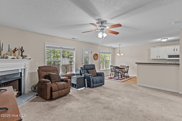 4979 Montserrat Dr, Southport, NC 28461 - living area featuring light colored carpet, a ceiling fan, a fireplace, a textured ceiling, and baseboards