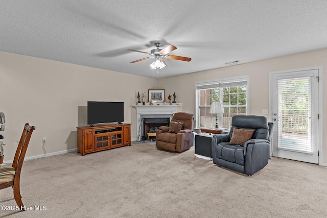 4979 Montserrat Dr, Southport, NC 28461 - living room with a ceiling fan, a fireplace, carpet, a textured ceiling, and baseboards
