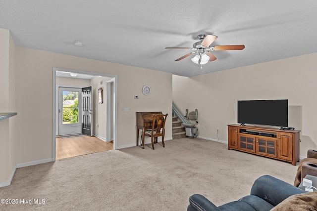 4979 Montserrat Dr, Southport, NC 28461 - carpeted living room featuring a ceiling fan, stairway, baseboards, and a textured ceiling