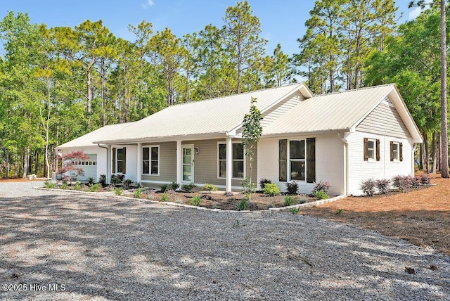 1324 S Shore Dr, Southport, NC 28461 - single story home featuring gravel driveway, an attached garage, brick siding, and metal roof