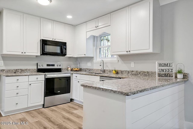 1324 S Shore Dr, Southport, NC 28461 - kitchen featuring electric stove, black microwave, a sink, white cabinetry, and a peninsula