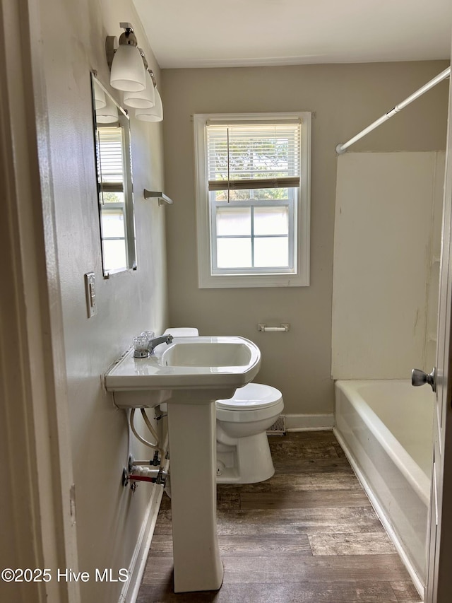 404 N Forbes St, La Grange, NC 28551 - bathroom featuring wood finished floors, toilet, tub / shower combination, and baseboards