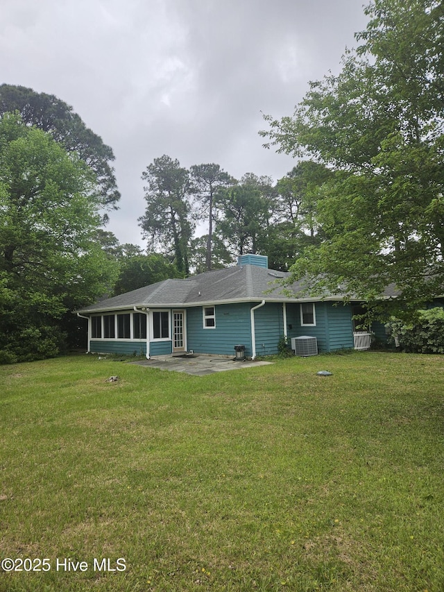 4 Cleek Ct, Carolina Shores, NC 28467 - rear view of property with a sunroom, a patio, a yard, a chimney, and central air condition unit