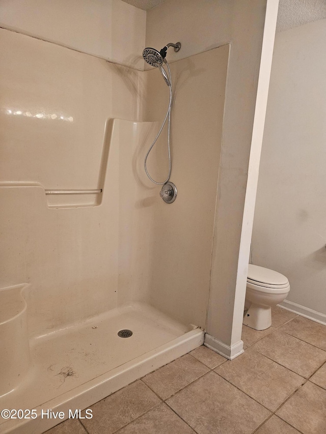 4 Cleek Ct, Carolina Shores, NC 28467 - full bathroom featuring tile patterned flooring, a stall shower, toilet, baseboards, and a textured ceiling