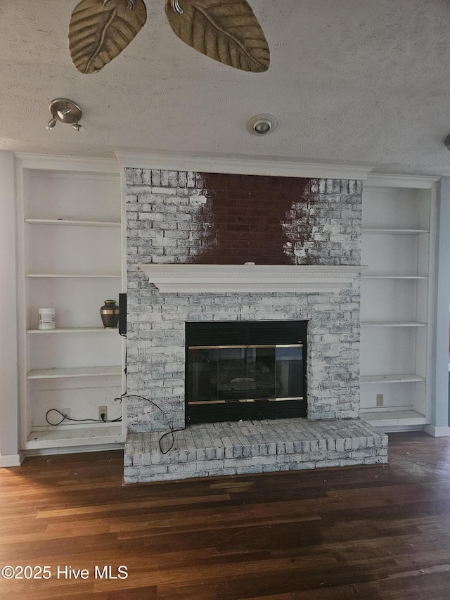 4 Cleek Ct, Carolina Shores, NC 28467 - detailed view of built in shelves, a glass covered fireplace, a textured ceiling, and wood finished floors