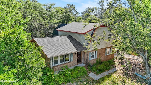 view of front of property with brick siding and roof with shingles
