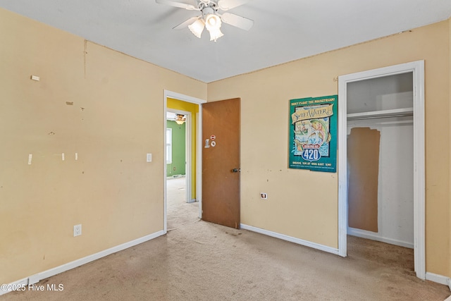 unfurnished bedroom featuring baseboards, a closet, carpet floors, and ceiling fan