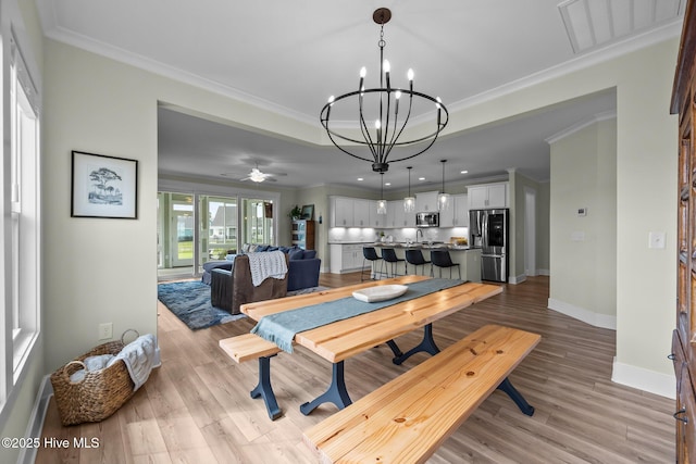 357 Spicer Lake Dr, Holly Ridge, NC 28445 - dining room with ornamental molding, a chandelier, light wood-type flooring, baseboards, and a ceiling fan