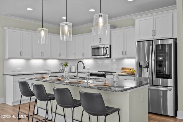 357 Spicer Lake Dr, Holly Ridge, NC 28445 - kitchen featuring appliances with stainless steel finishes, crown molding, white cabinetry, a kitchen bar, and backsplash
