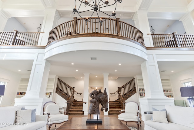 357 Spicer Lake Dr, Holly Ridge, NC 28445 - living room featuring ornate columns, stairs, wood finished floors, built in shelves, and a high ceiling