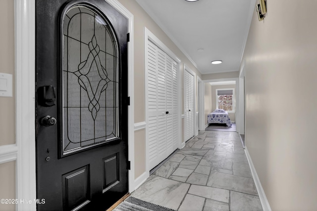 foyer entrance featuring baseboards and ornamental molding