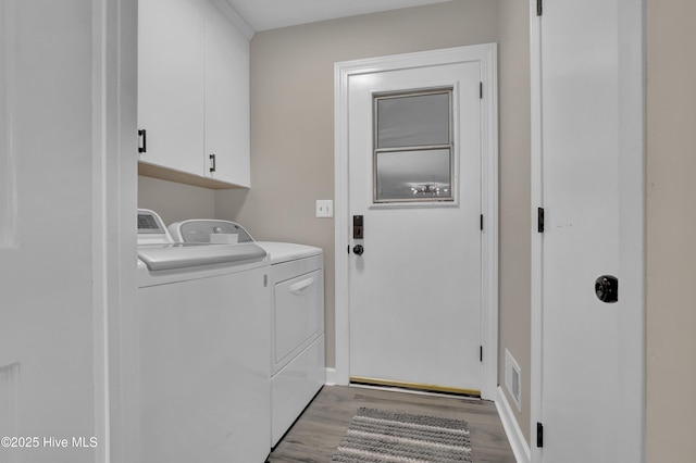 laundry area featuring washing machine and dryer, light wood-type flooring, cabinet space, and baseboards