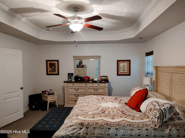bedroom featuring a tray ceiling, ornamental molding, carpet floors, a textured ceiling, and a ceiling fan