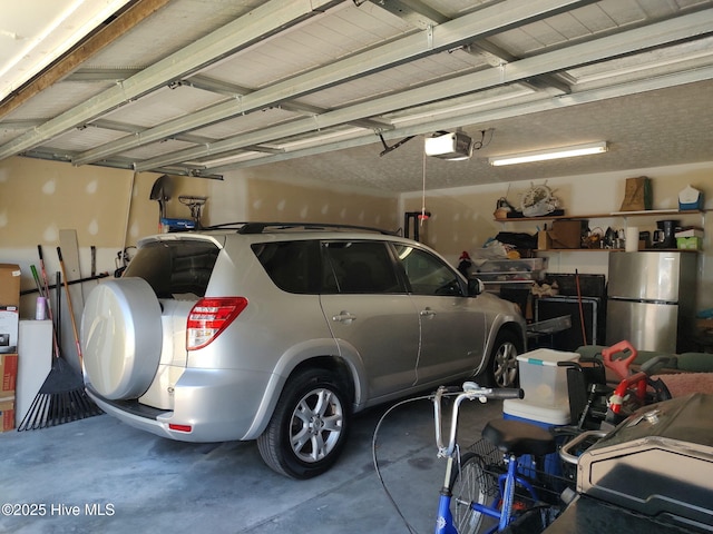 garage with freestanding refrigerator and a garage door opener