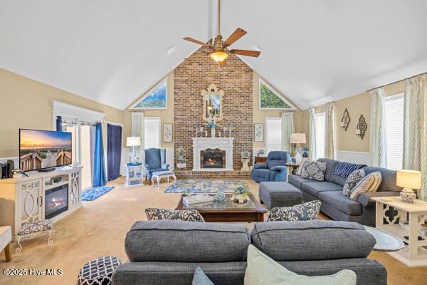 living area with a brick fireplace, ceiling fan, and high vaulted ceiling