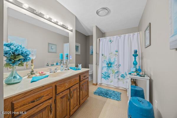 bathroom with toilet, vanity, and a shower with curtain