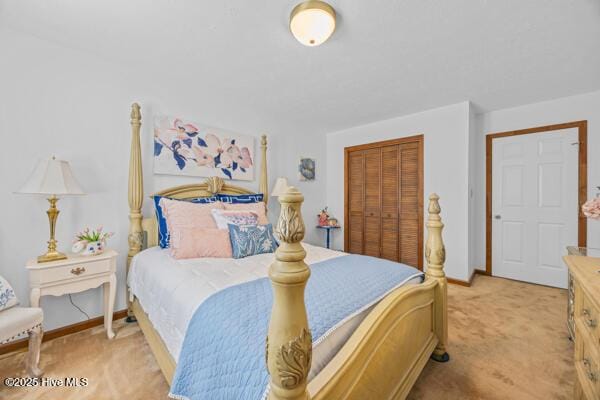 bedroom featuring light colored carpet, baseboards, and a closet