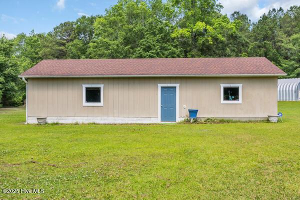 rear view of property with a yard