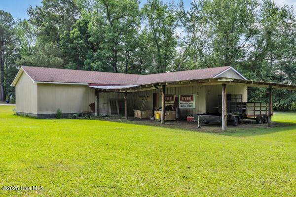 back of property with a yard and a carport