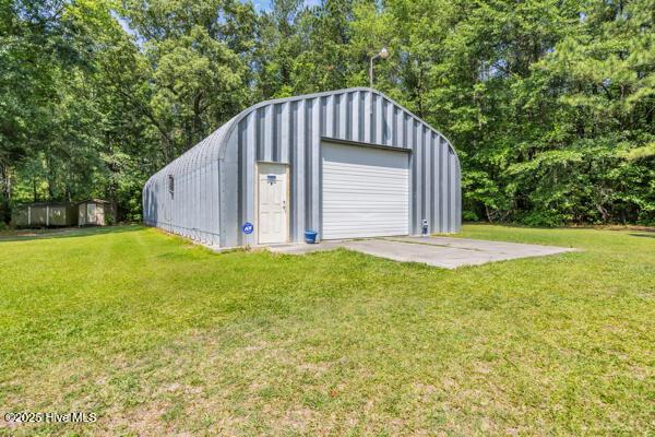 detached garage featuring view of scattered trees