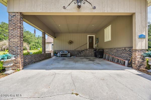 view of patio / terrace with driveway and a carport