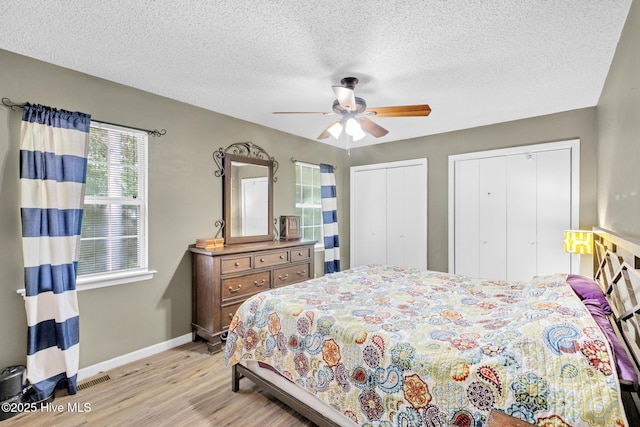 304 Pebble Ln, Jacksonville, NC 28546 - bedroom featuring light wood-style flooring, multiple closets, baseboards, a textured ceiling, and ceiling fan