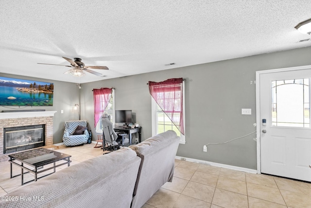 304 Pebble Ln, Jacksonville, NC 28546 - living room with tile patterned floors, a textured ceiling, a ceiling fan, a fireplace, and baseboards