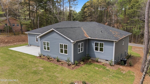 view of front facade featuring crawl space, a patio, a shingled roof, a front yard, and central AC unit