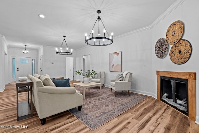 living room with a chandelier, crown molding, wood finished floors, baseboards, and recessed lighting
