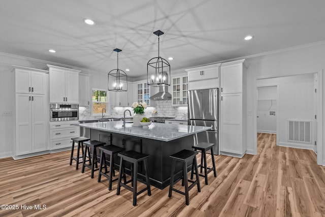 kitchen featuring stainless steel appliances, crown molding, white cabinets, recessed lighting, and decorative backsplash