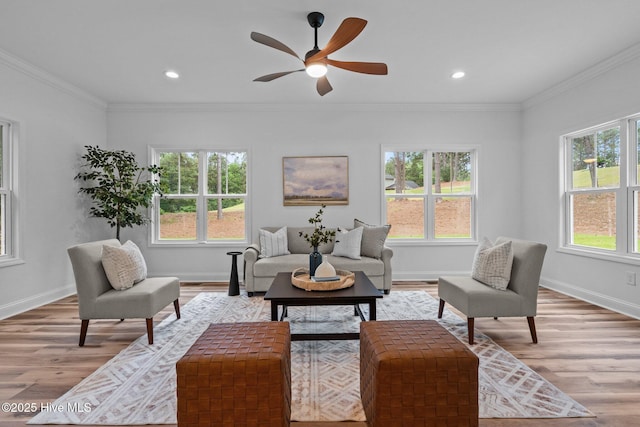 living room featuring light wood finished floors, baseboards, a ceiling fan, ornamental molding, and recessed lighting