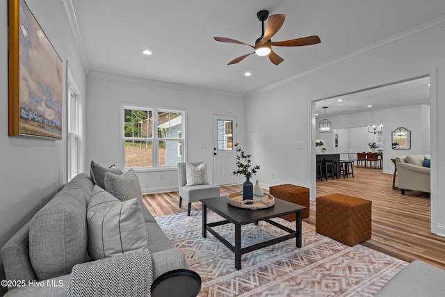 living room featuring light wood-style floors, ceiling fan, crown molding, recessed lighting, and baseboards
