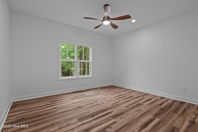 spare room with wood finished floors, a ceiling fan, baseboards, and recessed lighting