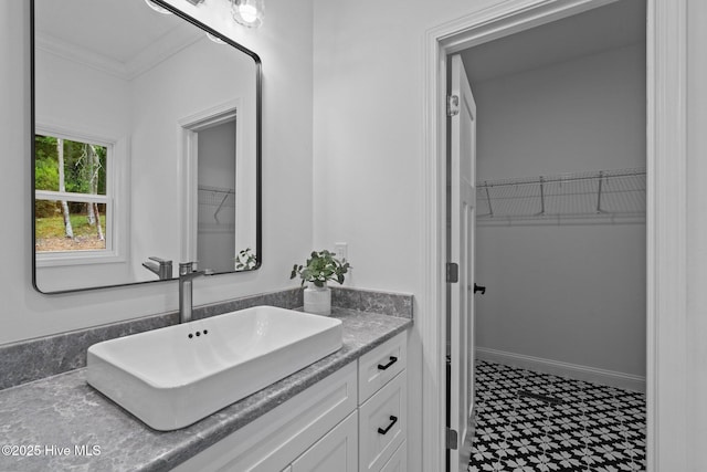 bathroom featuring tile patterned floors, vanity, a spacious closet, and ornamental molding