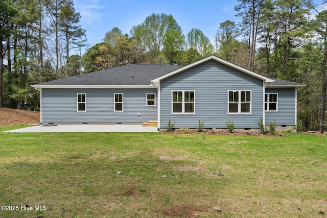 rear view of property with crawl space, a patio area, a yard, and a shingled roof