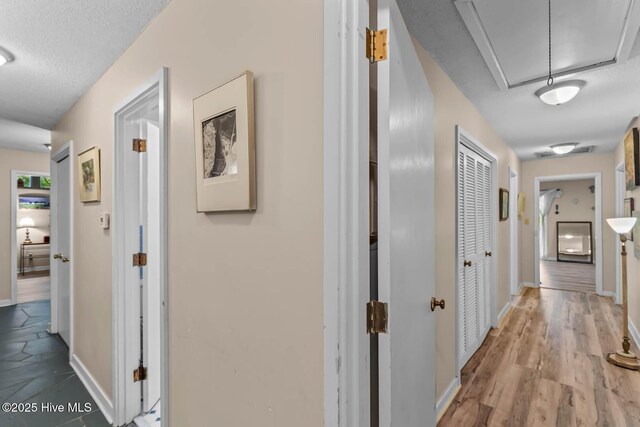 hall with attic access and baseboards