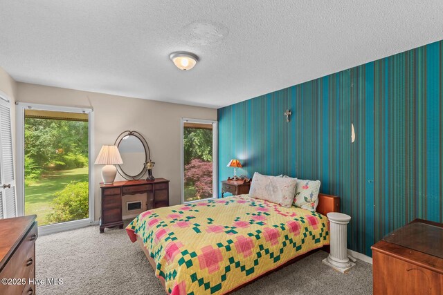 bedroom with carpet flooring, a textured ceiling, and baseboards