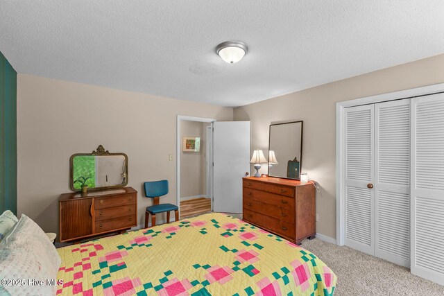 carpeted bedroom with a closet, a textured ceiling, and baseboards
