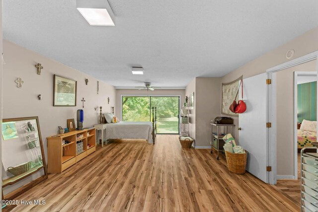 bedroom featuring light wood finished floors, ceiling fan, and baseboards