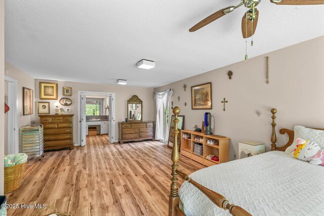bedroom with light wood-type flooring, a textured ceiling, a ceiling fan, and ensuite bathroom
