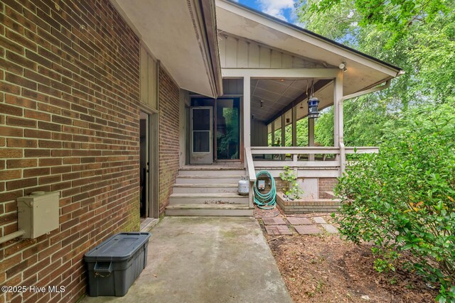 view of exterior entry with brick siding