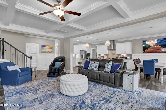 living area with a chandelier, wood finished floors, coffered ceiling, ceiling fan, and crown molding